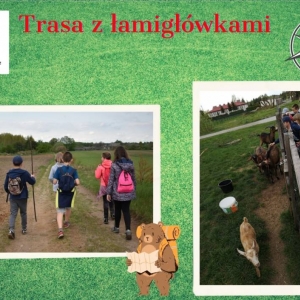 Dzieci idący polną drogą w kierunku domostw znajdujących się w tle, kozy znajdujące się w zagrodzie po której z drugiej strony znajdują się uczestnicy spaceru wyciągają do kóz by je pogłaskać ręce 